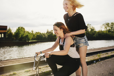 Two friends riding BMX bicycle together stock photo