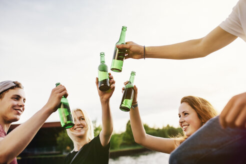 Freunde trinken gemeinsam Bier am Wasser - GCF000081