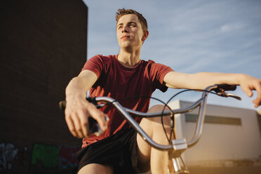 Junger Mann mit BMX-Fahrrad schaut weg - GCF000089