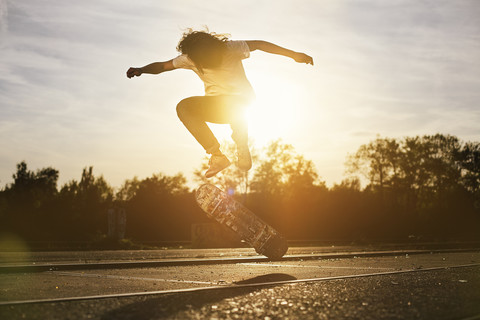 Junger Mann auf Skateboard im Gegenlicht, lizenzfreies Stockfoto