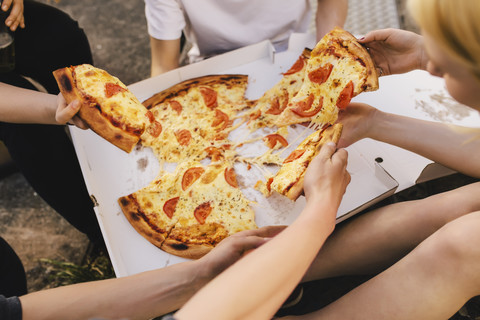 Friends sharing a pizza stock photo