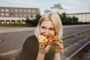 Freunde sitzen im Freien zusammen und teilen sich eine Pizza - GCF000099