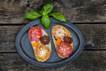 Tomato bread with Heirloom tomatoes and basil on a wooden table - SARF001842