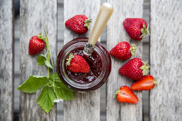 Strawberry jam in glass, strawberries on wood - SARF001851