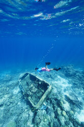 Maldives, woman snorkeling in the Indian Ocean at sunken boat - STKF001300