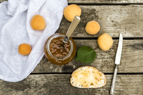 Ein Glas Aprikosenmarmelade und Brot mit Aprikosenmarmelade, lizenzfreies Stockfoto