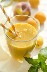 Peach-apricot-smoothie in a glass with drinking straw - ODF001136