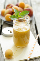 Peach-apricot-smoothie in a glass with drinking straw - ODF001137
