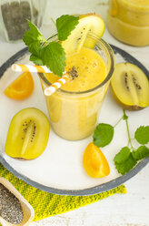 Aprikosen-Kiwi-Smoothie mit Chiasamen und Minze in einem Glas mit Trinkhalm - ODF001138