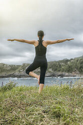 Spain, Gijon, woman doing yoga exercises - MGOF000282