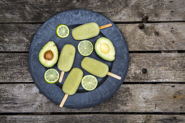 Plate of avocado ice lollies, sliced avocado and slices of lime - SARF001873