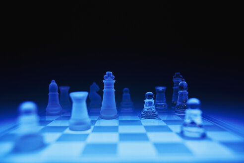 Schachfiguren auf blauem Glasbrett vor dunklem Hintergrund - DSCF000194