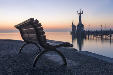 Germany, Baden-Wuerttemberg, Constance, Lake Constance, empty bench and harbour entrance with Imperia Statue at twilight - KEBF000198