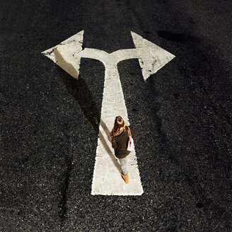 Woman walking on directional arrow of a road - MMFF000851