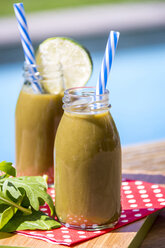 Zwei Glasflaschen mit Spinat-Smoothie mit Rucola und Limette - JUNF000313