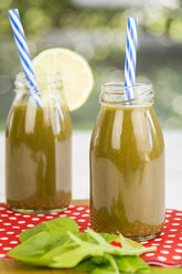 Two glass bottles of spinach smoothie with rocket and lime - JUNF000314