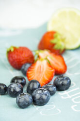 Blueberries, strawberries and lime on cloth - JUNF000315