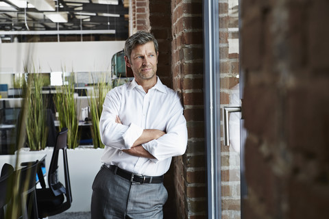 Businessman in office looking out of window stock photo