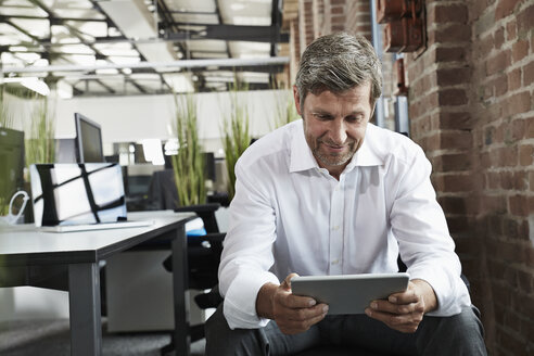 Geschäftsmann im Büro mit Blick auf eine digitale Tafel - PDF001008