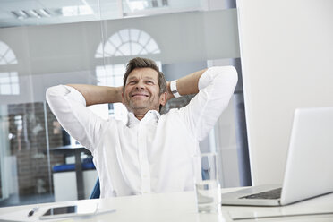 Portrait of smiling businessman in office relaxing - PDF001019