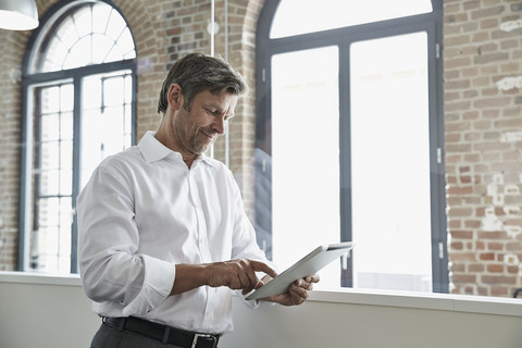 Geschäftsmann im Büro mit digitalem Tablet, lizenzfreies Stockfoto
