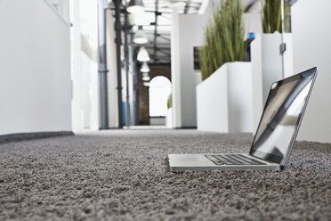 Laptop auf Teppich im Büro - PDF001067