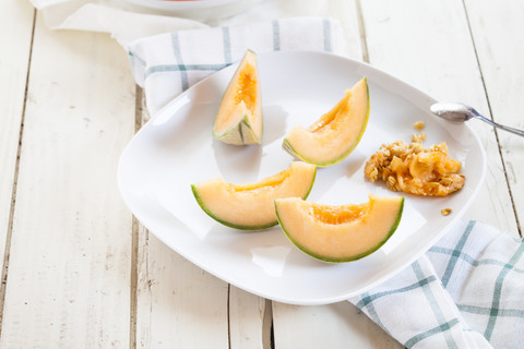 Teller mit in Scheiben geschnittener und entkernter Charentais-Melone, lizenzfreies Stockfoto