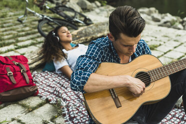Entspanntes junges Paar mit Gitarre im Freien - UUF004753