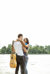 Young couple embracing by the riverside - UUF004794