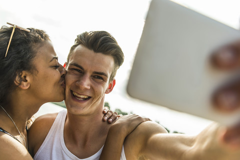 Glückliches junges Paar macht ein Selfie im Freien, lizenzfreies Stockfoto