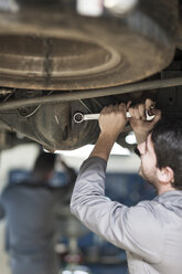 Automechaniker bei der Arbeit mit einem Schraubenschlüssel in einer Reparaturwerkstatt - ZEF005681