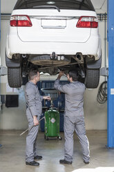 Zwei Automechaniker bei der Arbeit in einer Reparaturwerkstatt - ZEF005683