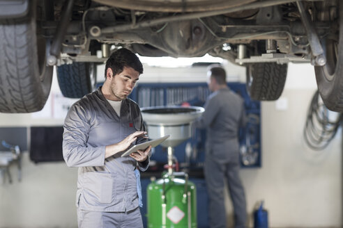 Automechaniker mit digitalem Tablet in der Werkstatt - ZEF005688