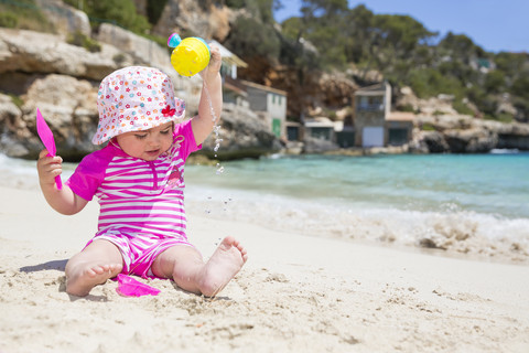 Spain, Baleares, Mallorca, baby girl playing on sandy beach stock photo