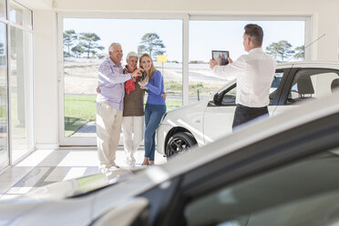 Autohändler beim Fotografieren einer glücklichen Familie mit Autoschlüssel - ZEF006342