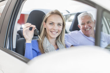 Portrait of smiling woman holding key in new car - ZEF006377