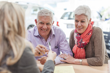 Smiling senior couple at car dealer - ZEF006382