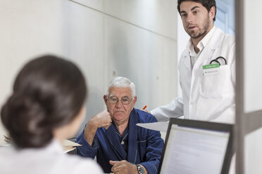 Nurse and doctor helping patient at clinic reception - ZEF005927