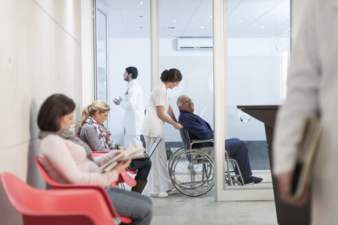Krankenschwester schiebt Patient im Rollstuhl im Wartebereich - ZEF005933