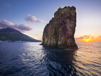 Italien, Sizilien, Äolische Inseln, Blick auf Isola Stromboli, Isola Strombolicchio mit Leuchtturm bei Sonnenuntergang - AMF004080