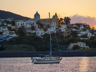 Italien, Sizilien, Äolische Inseln, Blick auf Isola Stromboli, Segelboot bei Sonnenuntergang - AMF004083