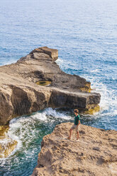 Greece, Aegean Islands, Rhodes, young man looking to rocky island - WDF003137