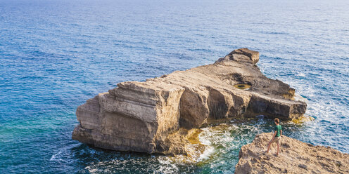 Griechenland, Ägäische Inseln, Rhodos, junger Mann auf der Suche nach einer felsigen Insel - WDF003138