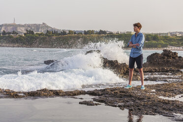 Greece, Rhodes, young man standing at seafront looking at distance - WDF003142