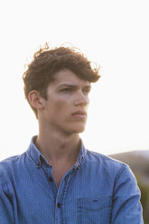 Portrait of serious looking young man at backlight - WDF003146