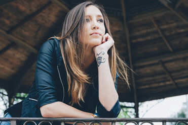 Portrait of pensive young woman with hand on chin looking at distance - GEMF000242