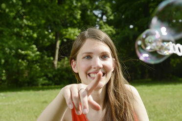 Junge Frau spielt mit Seifenblasen - BFRF001259