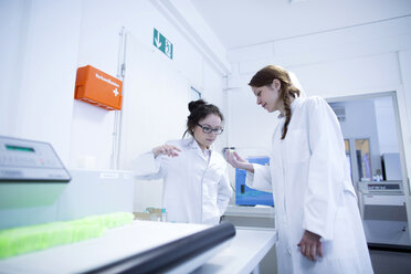 Medical laboratory assistants discussing samples - SGF001702
