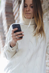 Portrait of young woman looking at her smartphone - GIOF000023