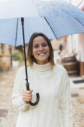 Italien, San Gimignano, Porträt einer lächelnden jungen Frau mit Regenschirm - GIOF000025